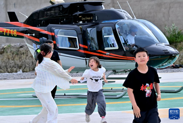 5月2日，在湖北省恩施州宣恩县贡水河畔，刚刚体验乘坐直升机的小女孩兴奋不已。
