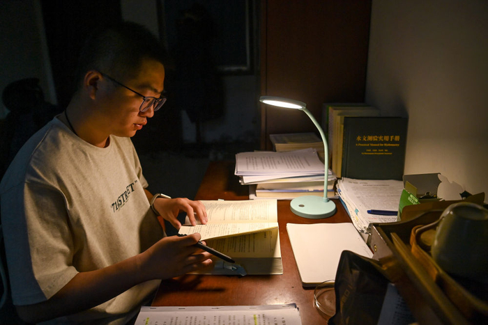 4月28日，龙门水文站职工霍鸣冲在宿舍学习水文知识。新华社记者 邹竞一 摄