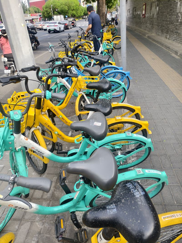 距离学校200米处，低俗小广告被喷到多辆共享单车的车座上。新京报记者 曹晶瑞 摄