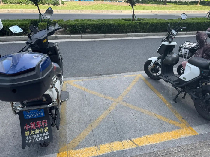 △普陀某商圈，为方便外卖小哥停车，在上街沿增设坡道垫。（车佳楠/摄）