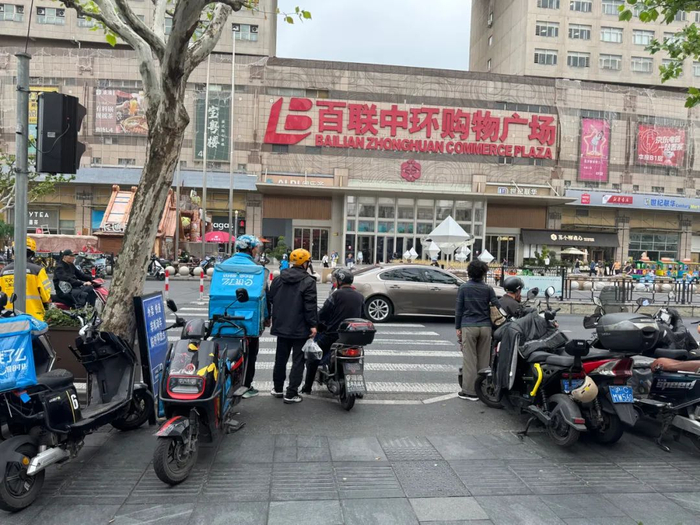 △百联中环购物广场前的真光路西侧，有外卖、快递非机动车临时停放点。（车佳楠/摄）