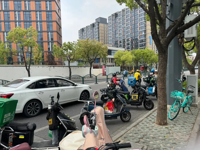 △浦东某商场周边，外卖小哥将车辆停放在非机动车道上。（车佳楠/摄）
