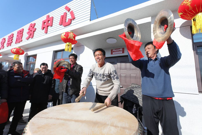 2025年1月28日，葫芦岛市绥中县明水满族乡祝家沟村村民在重建新房的村党群服务中心前鸣锣击鼓。新华社发 田嘉摄