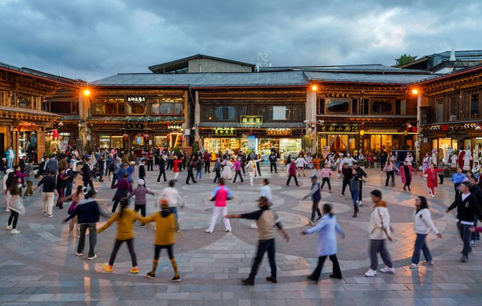 游客和当地群众在云南省迪庆州香格里拉市独克宗古城里一起跳舞（2024年9月27日摄）。新华社记者 王静颐 摄