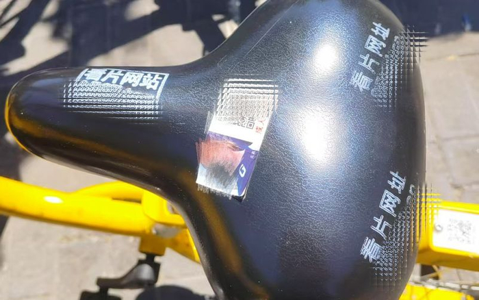 有的共享单车座椅上，被喷涂了多个广告。新京报记者 曹晶瑞 摄