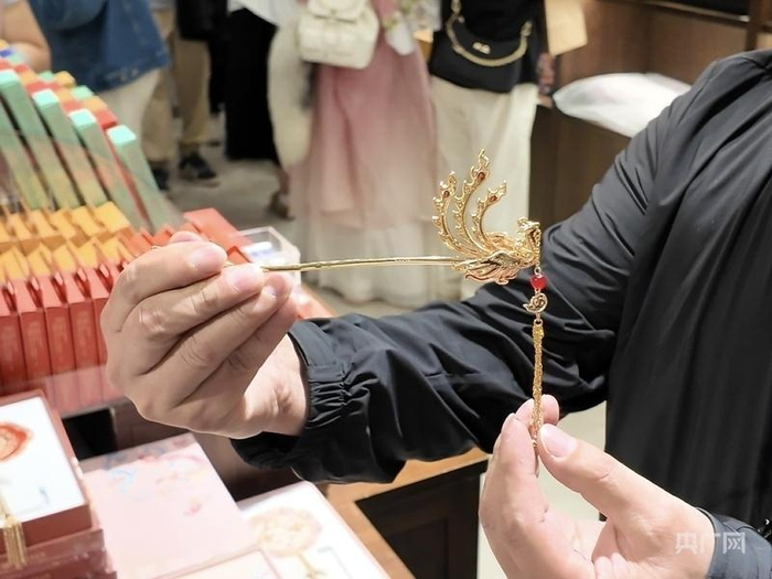 湖北省博物馆工作人员向记者展示“一绾青丝·凤凰于飞发簪”（央广网发 实习记者陈彦如 摄）