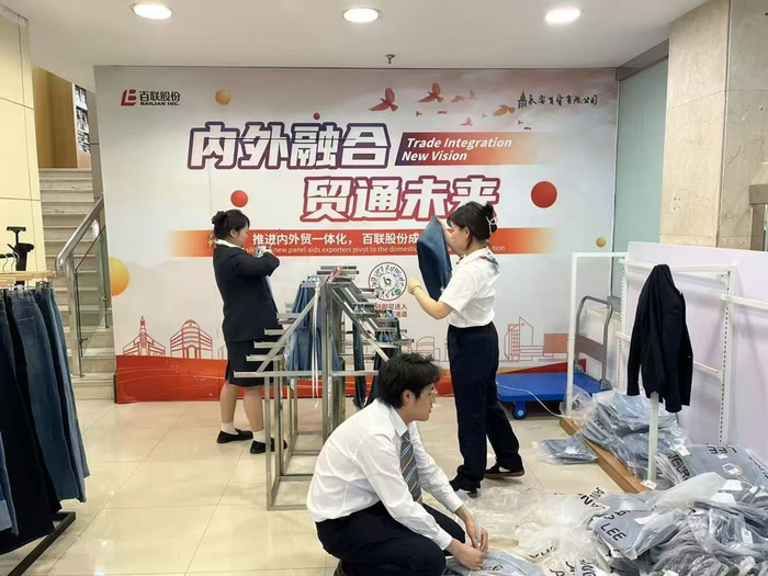 5月2日，永安百货的工作人员将刚刚收到的外贸牛仔裤上架。          受访者供图