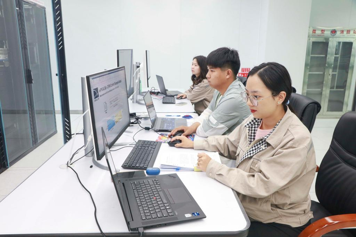 吴小芳（右）和同事在国网新疆电科院实验室开展新能源控制器半实物仿真测试工作（2024年7月20日摄）。新华社 丁文静 摄