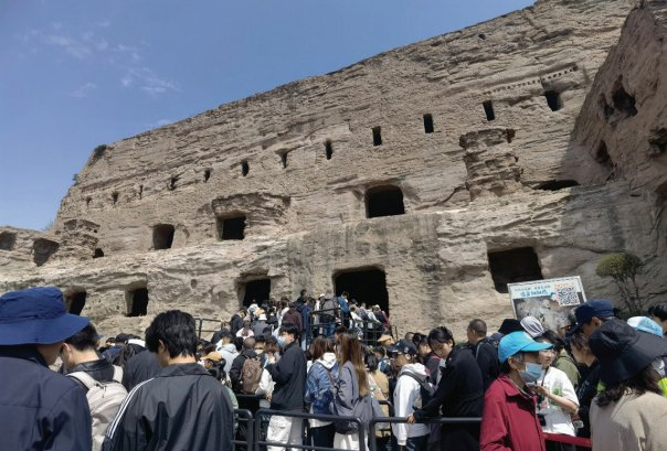 　　图为游客有序排队等待进入石窟参观。