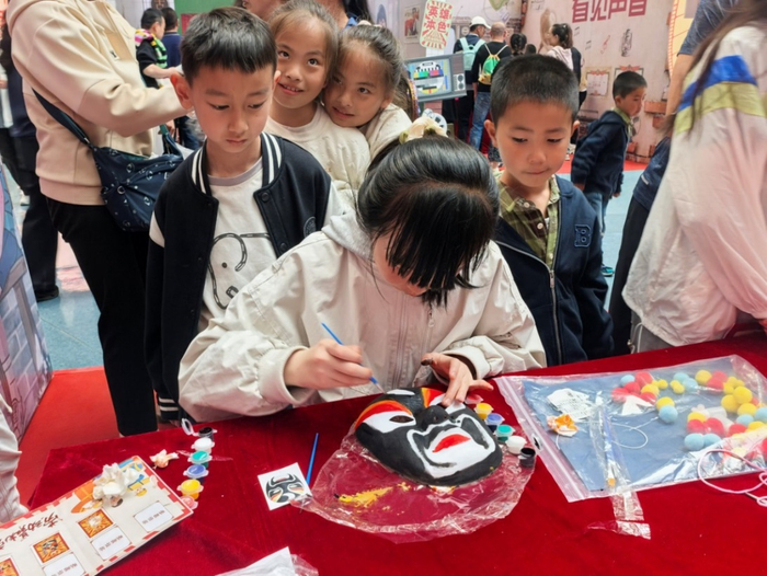 △在“八零东方韵”主题展区“千面丹青”活动中，小朋友们正在亲手绘制脸谱。（青海省科技馆供图）
