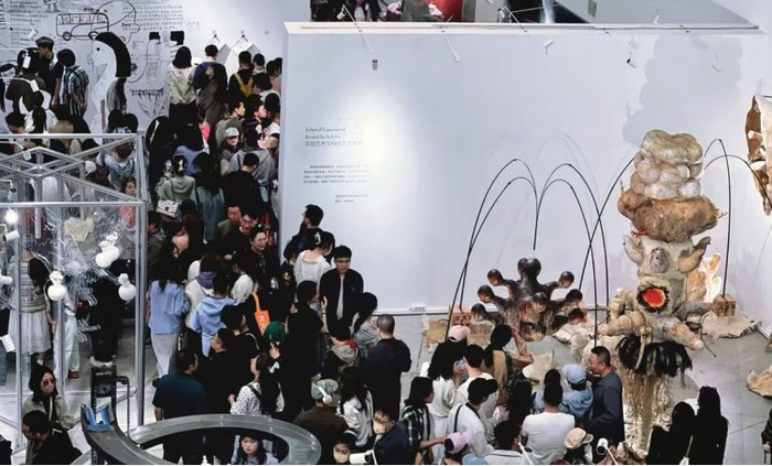 　　图为展览期间，观众在展品前排起长队，等待欣赏创意十足的作品。