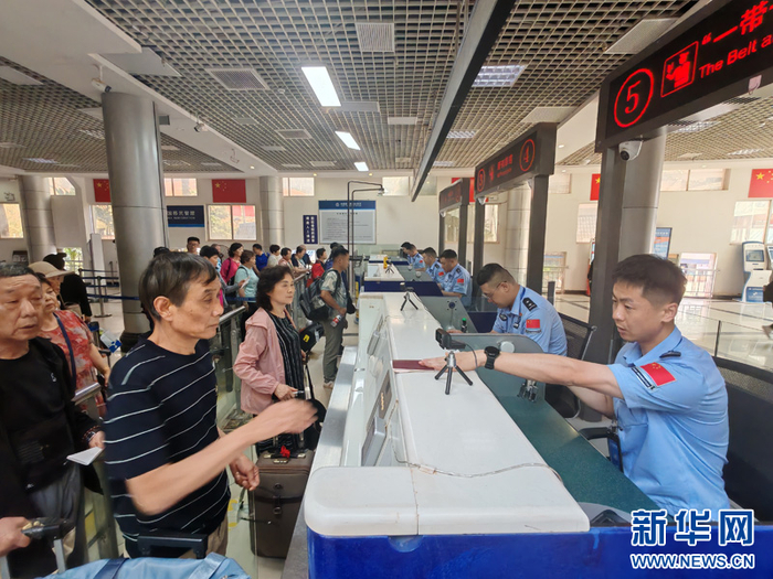 磨憨口岸边检执勤现场民警正在验放旅客（5月3日摄）。新华网发（黄远飞 摄）