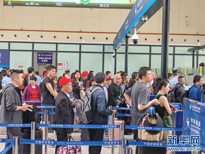 磨憨铁路口岸边检执勤现场旅客排队验证出境（5月2日摄）。新华网发（黄远飞 摄）