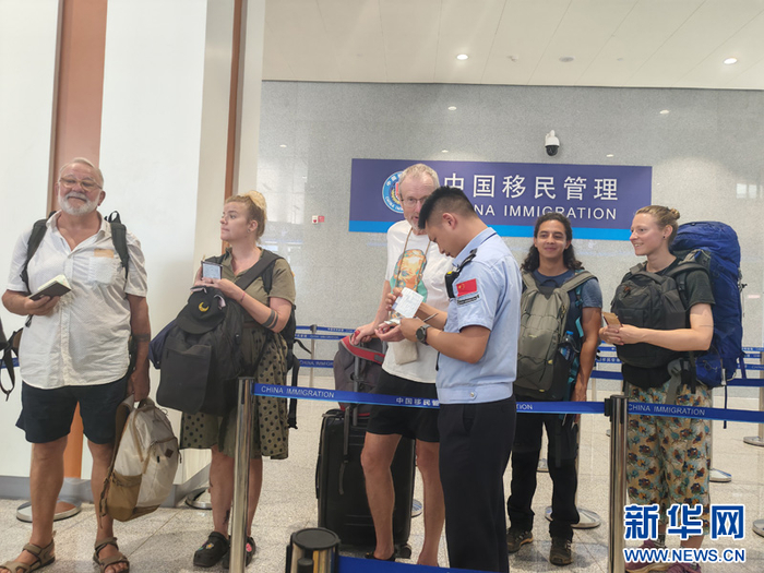 移民管理警察查验外籍游客证件（5月3日摄）。新华网发（黄远飞 摄）