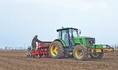 图为韩立光驾驶播种机播撒玉米种子。记者 郑智文摄