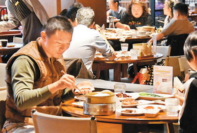 顾客在全聚德烤鸭北京和平门总店品尝挂炉烤鸭。新华社记者 李欣 摄