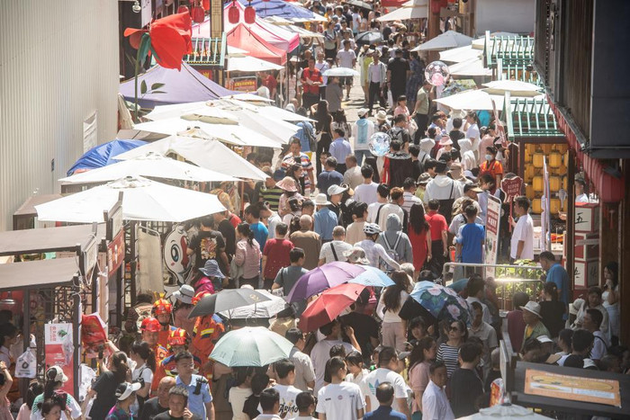 5月2日，游客在重庆市荣昌区的夏布小镇景区美食、逛古镇。新华社记者 唐奕 摄
