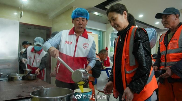 志愿者为前来用餐的环卫工人打饭 刘星辰 摄