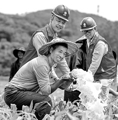     在福建省福州市马尾区琅岐岛的一处玉米地，福州供电公司员工帮助农户使用共享电源进行灌溉。谢贵明摄/光明图片