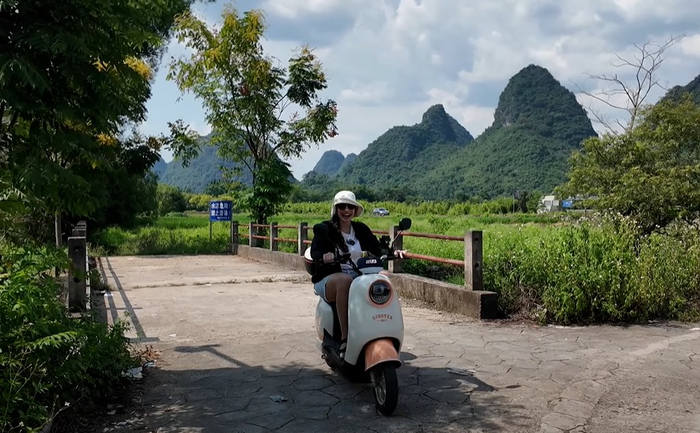 Rita乘坐电动车驰骋在广西桂林阳朔的山间小径。受访者供图