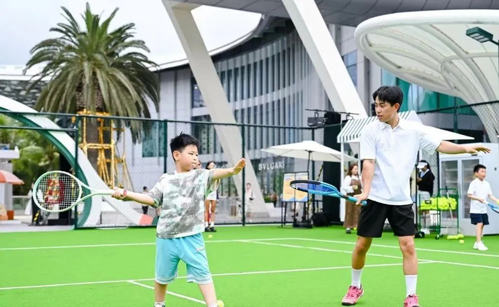 ▲“五一”假期，游客在三亚国际免税城旅游区购物之余，体验网球运动。