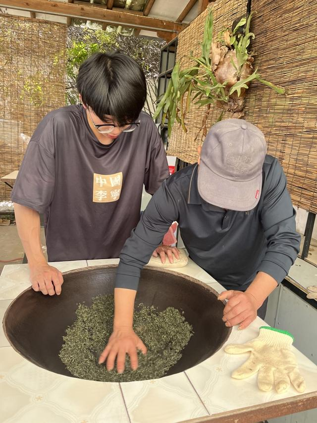 曹君玉在指导郭书瀚炒茶，刘畅 摄