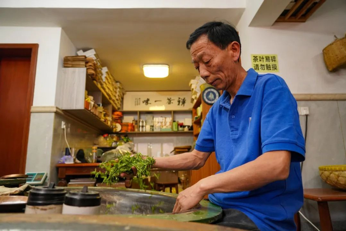 樊生华正在炒制茶叶。章勇涛 摄