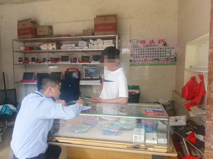 图为工作人员向涉诉维修店老板了解情况。