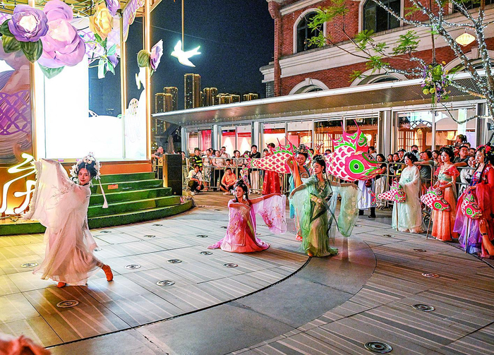     游人在弹子石广场观看民俗表演