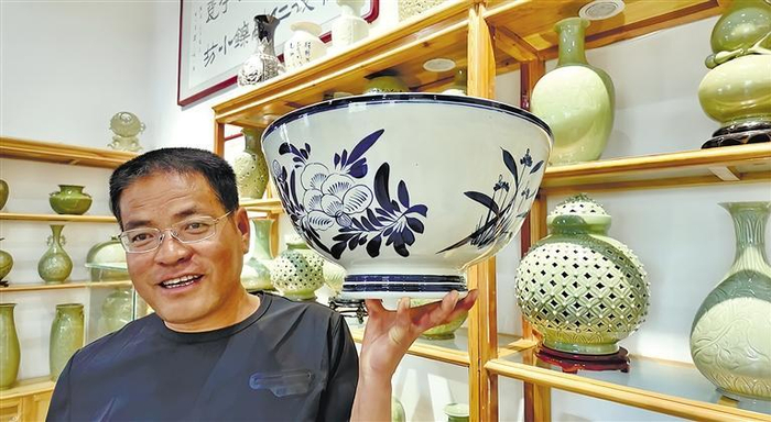 王家瓷坊负责人王战军展示作品。 本报记者 赵茁轶摄