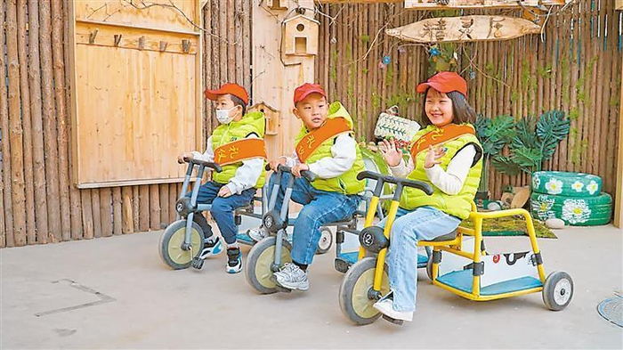 金凤区第一幼儿园大班的小朋友们化身“专车司机”，骑着三轮小车接送小班小朋友。记者　陈瑶　摄