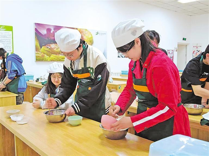 学生穿上厨师服，戴上厨师帽，学习做面点。记者　杨嘉琪　陈瑶　摄