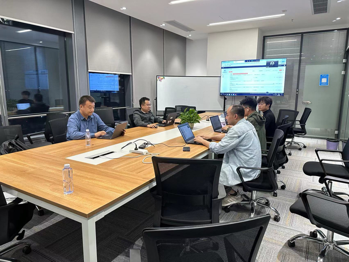 　　侯晓东带领团队在讨论研究业务方案。