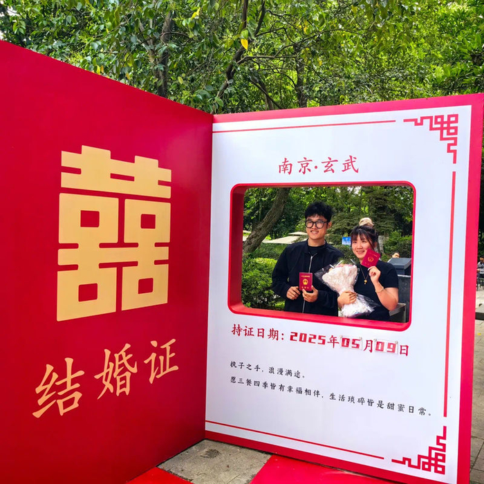 ▲5月9日，南京市玄武区婚姻登记处在玄武湖环洲正式启用，新人领证后留影纪念。图/南京发布