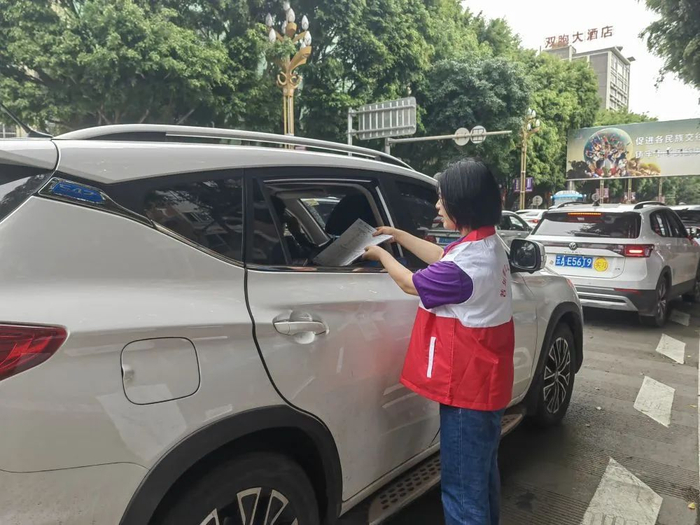 5月2日，云南省墨江哈尼族自治县一名志愿者向游客发放节庆活动行程单。（墨江县融媒体中心供图）