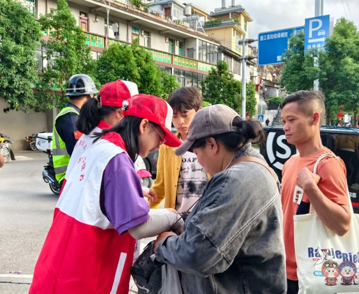 5月2日，云南省墨江哈尼族自治县两名志愿者向游客提供服务。（墨江县融媒体中心供图）