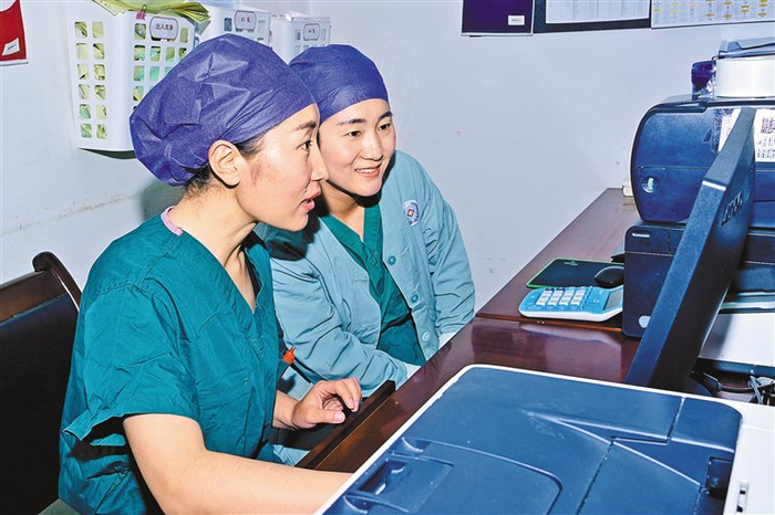 图为索朗玉珍（左）与同事讨论科研内容。记者 王敏 摄