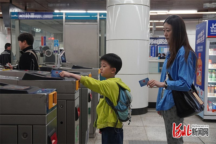 5月1日，在北京地铁7号线进站口，范芮洁和儿子通过刷社保卡，顺利乘坐上北京的地铁。 保定市人社局供图