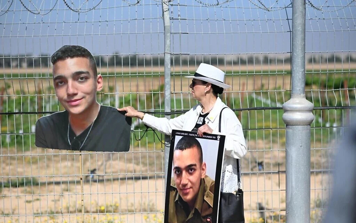 △2025年4月20日，艾丹·亚历山大的祖母在加沙地带边境附近手捧被扣押的艾丹的照片。（来源：《以色列时报》）