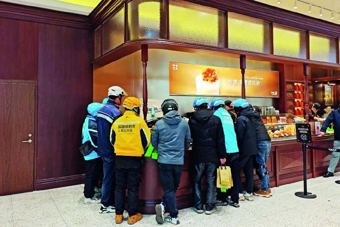 在上海一家茶楼等待取餐的外卖员。本文图/视觉中国
