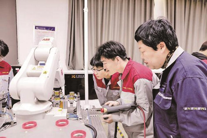     4月28日，在唐山工业职业技术大学自动化工程学院，老师正指导学生操作工业机器人。    河北日报记者 师源 摄