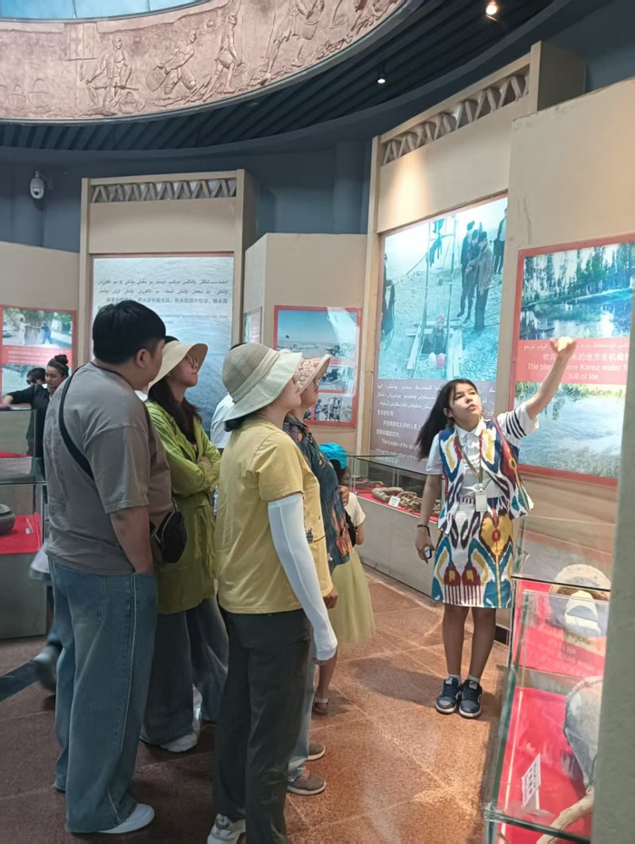 女儿努尔孜亚在给游客讲解坎儿井的故事。吐尔逊娜依·胡吉艾合买提供图