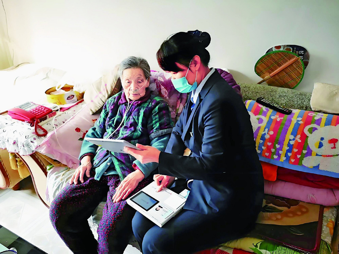 张店农商银行工作人员（右）上门为有需要的老年客户提供金融服务。程科/摄