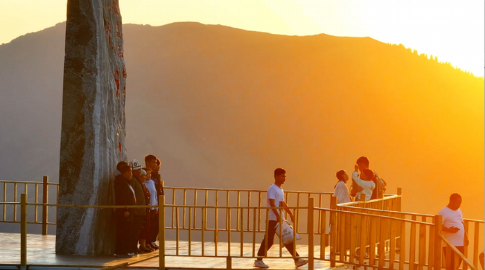 游客在伊昭公路合影留念。周森镇摄