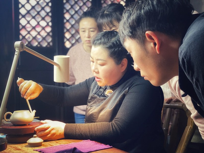 田静委员（中）正在示范紫陶制作技艺。