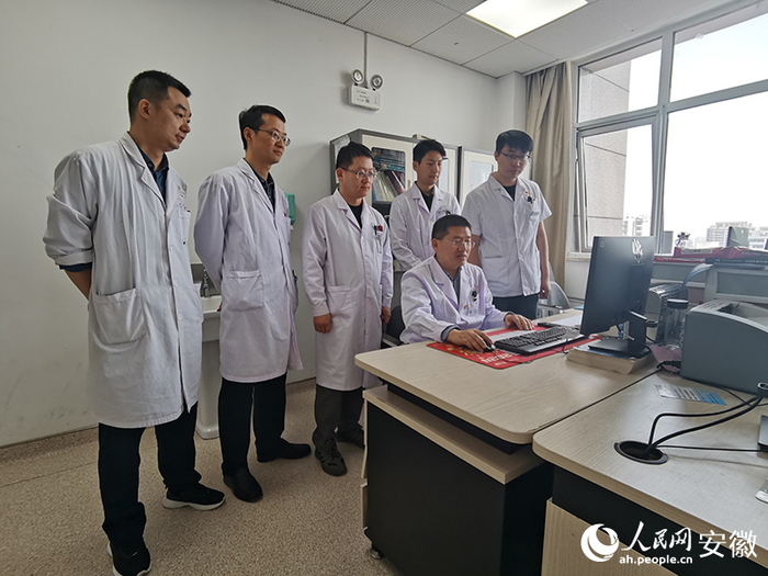 刘大闯（右二）与团队成员研究患者病情。人民网 胡雨松摄
