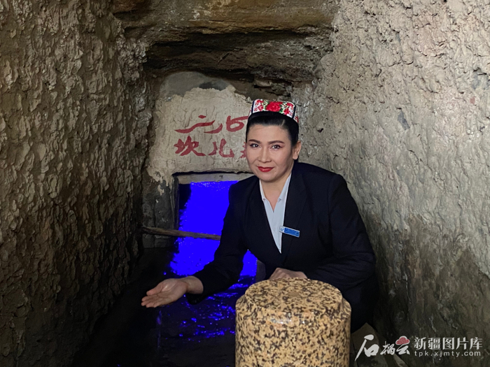吐尔逊娜依·胡吉艾合买提在坎儿井地下暗渠讲解。石榴云/新疆日报记者 赵梅摄