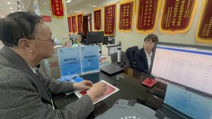 阿城区政务服务中心工作人员向办事人介绍“跨级联办”