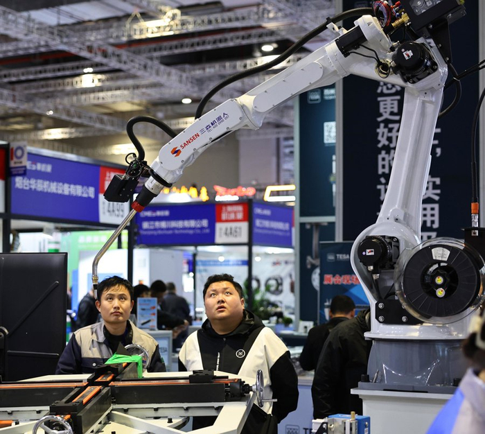 参观者在2025上海国际机床展一个进行作业演示的机器人前驻足。 新华社 发