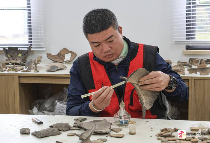 工作人员正在修复出土的陶器。